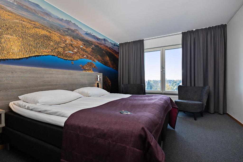 a hotel room with a bed and a large painting on the wall at Comfort Hotel Umeå City in Umeå