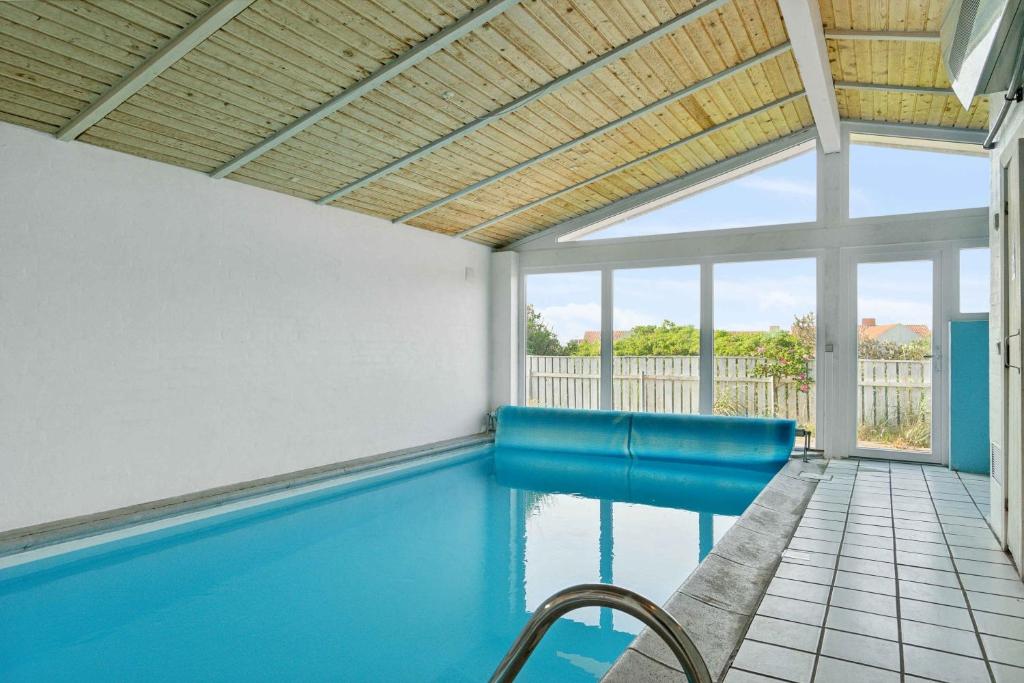 una piscina con tavolo e sedie in una casa di Pool House Close To The Coast a Vestervig