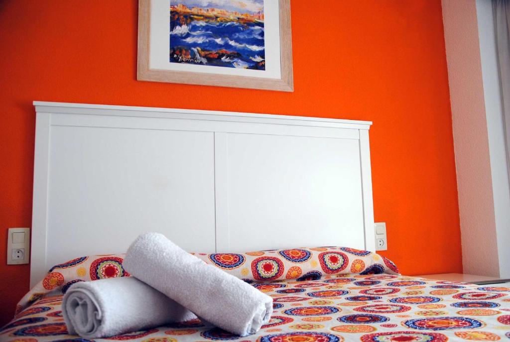 - une chambre dotée d'un lit avec un mur orange dans l'établissement Valencia Centro WiFi, à Valence