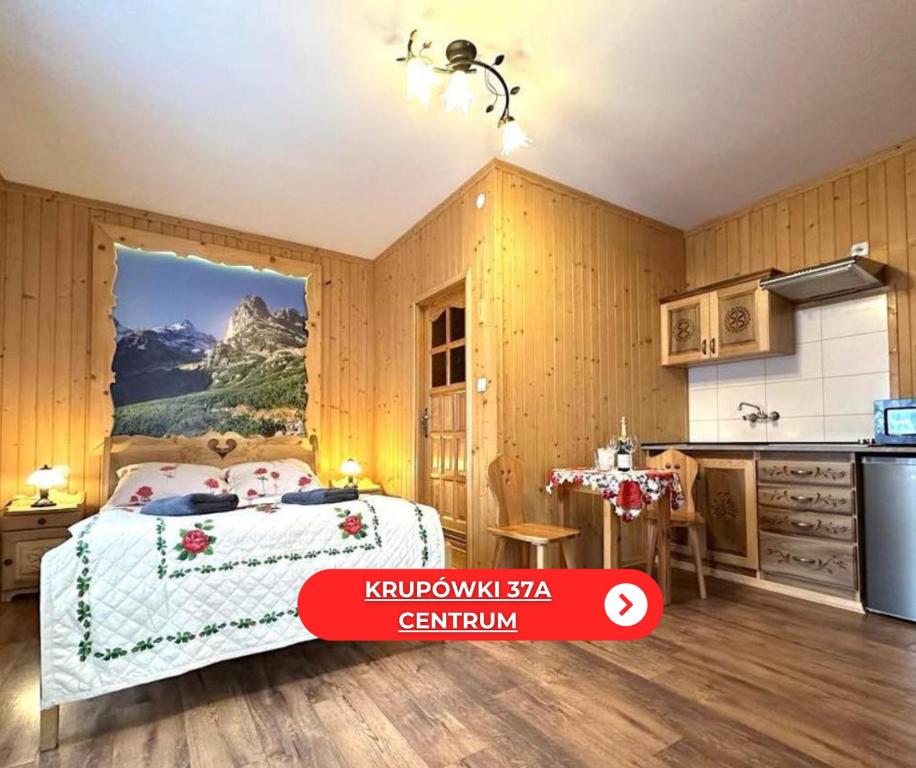 a kitchen and a bedroom with a bed in a room at Wesoła Chatka - Krupówki 37a -CENTRUM in Zakopane