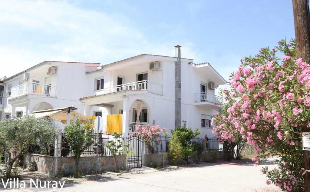 a white house with pink flowers in front of it at Villa Nuray in Keramoti