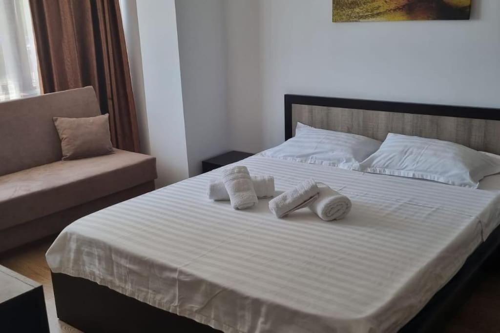 una camera da letto con un letto con asciugamani sopra di Studio Sat Vacanta Free parking a Constanţa