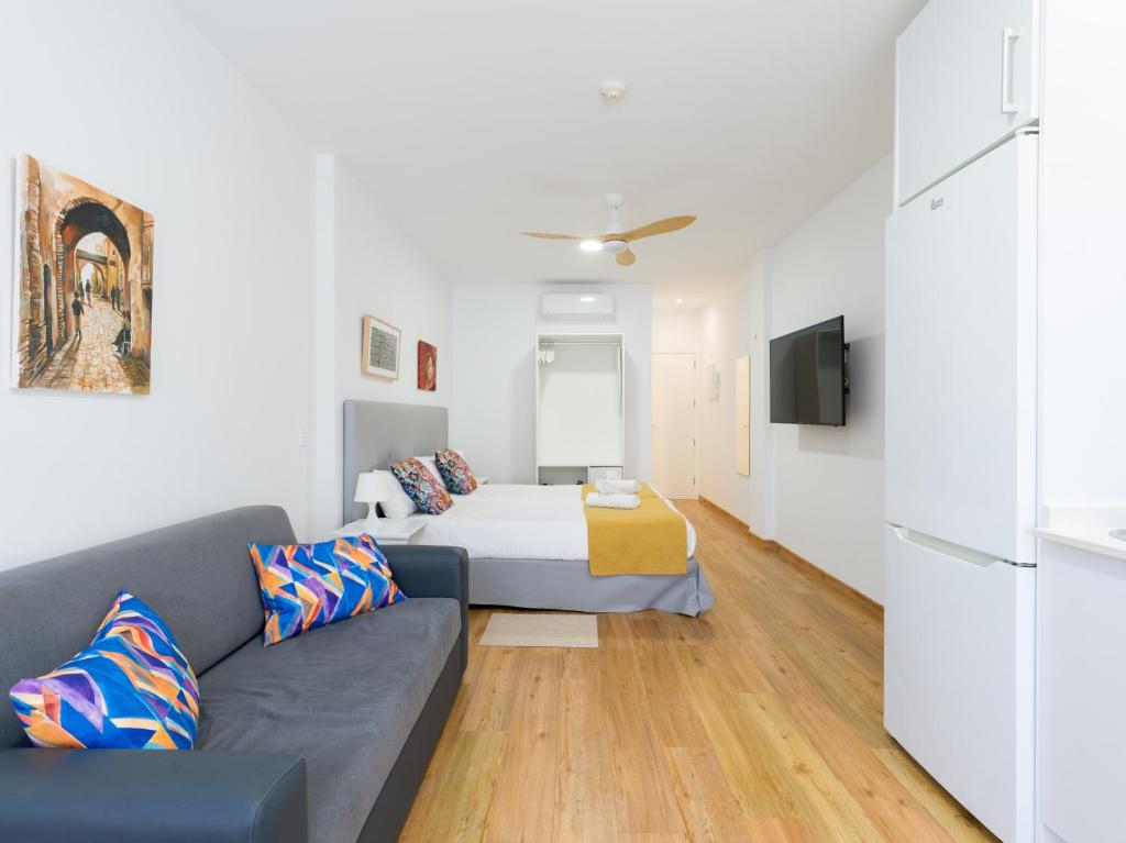 ein Wohnzimmer mit einer Couch und einem Bett in der Unterkunft Ok Las Canteras Beach by CanariasGetaway in Guanarteme