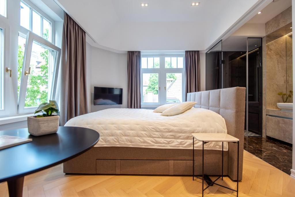 サラエボにあるEngadin Suite in Heart of Cityの大きなベッドとテーブルのある寝室