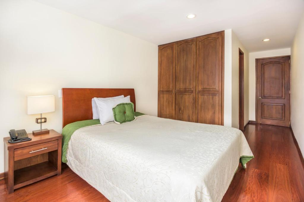 a bedroom with a bed and a dresser at Hotel Portofino in Bogotá