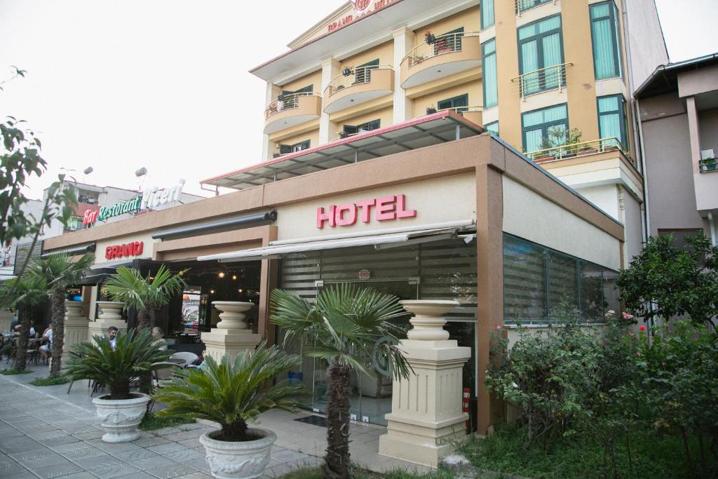 un hotel con palmeras frente a un edificio en Grand Hotel, en Elbasan