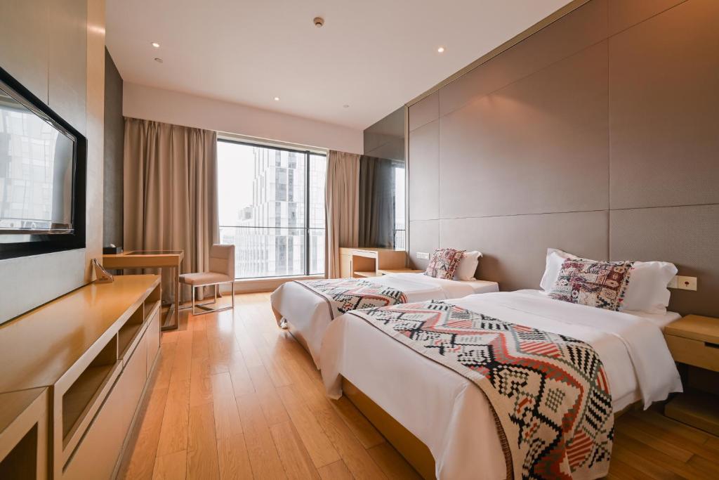 Postel nebo postele na pokoji v ubytování Snug Gaokong Jiangjing Hotel