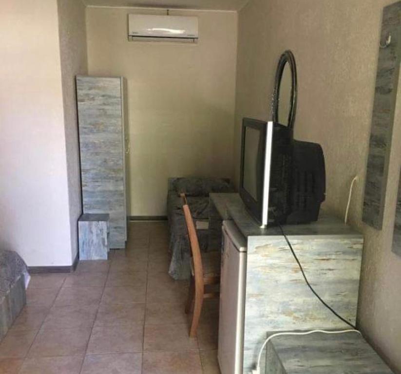 a living room with a tv and a table with a tableablish at Комплекс Дворъ in Varna City