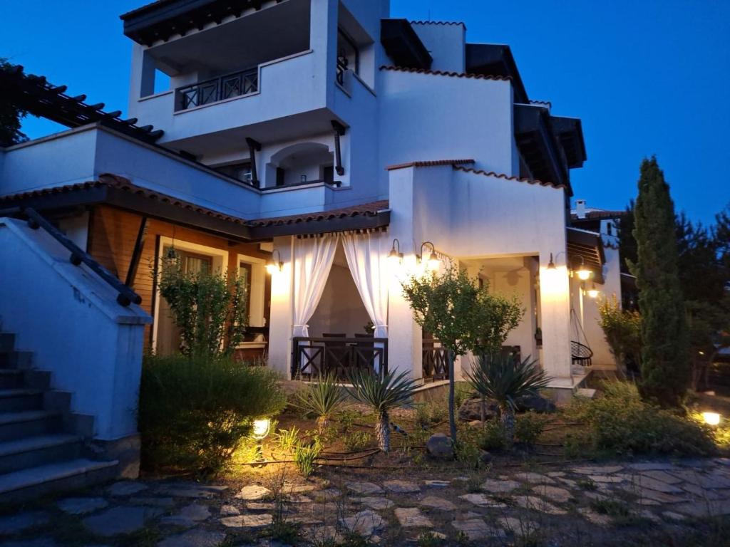 a white house with lights in the night at Bogdanov in Lozenets