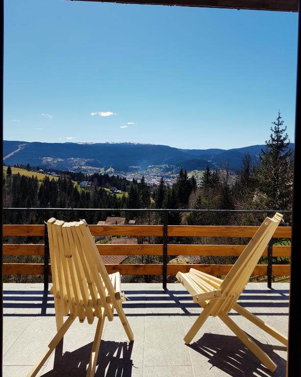 two wooden chairs sitting on top of a balcony at Vikendica Zlatni Hrast Jahorina Pale in Pale