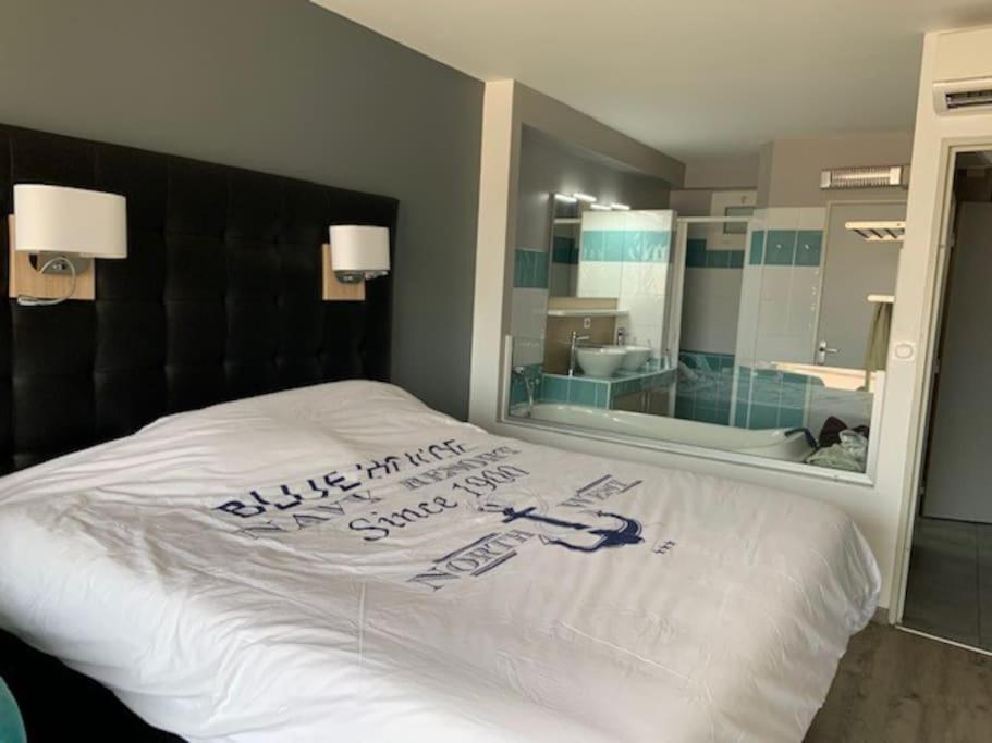 - un lit avec une pancarte dans une chambre dans l'établissement Jardin d eden village naturiste, au Cap d'Agde