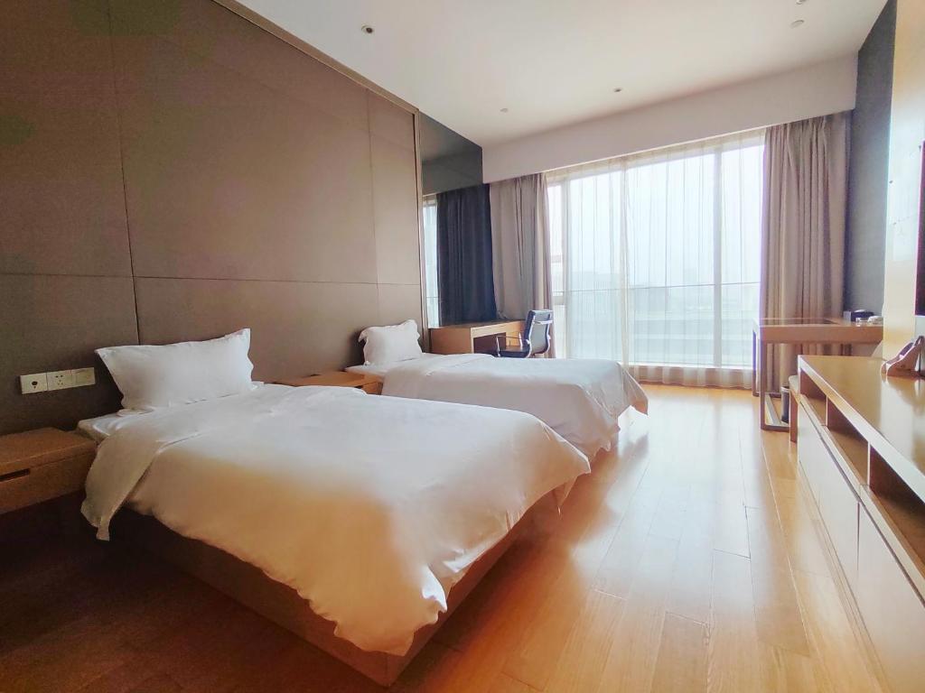Postel nebo postele na pokoji v ubytování Snug Gaokong Jiangjing Hotel