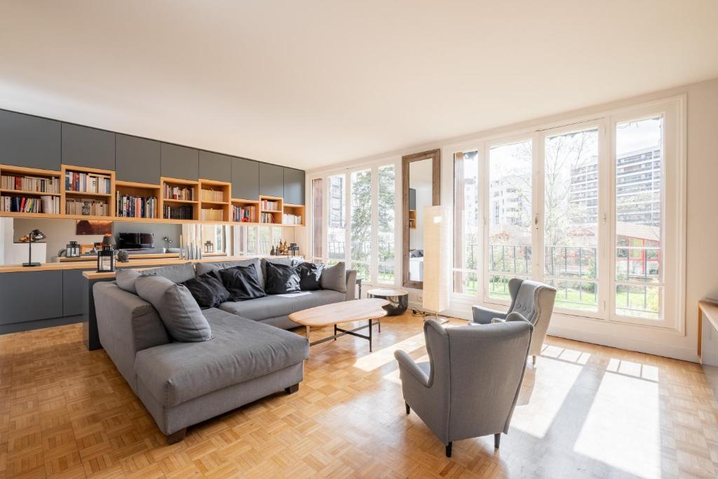 un salon avec un canapé, des chaises et une table dans l'établissement Veeve - Grand in Grey, à Paris