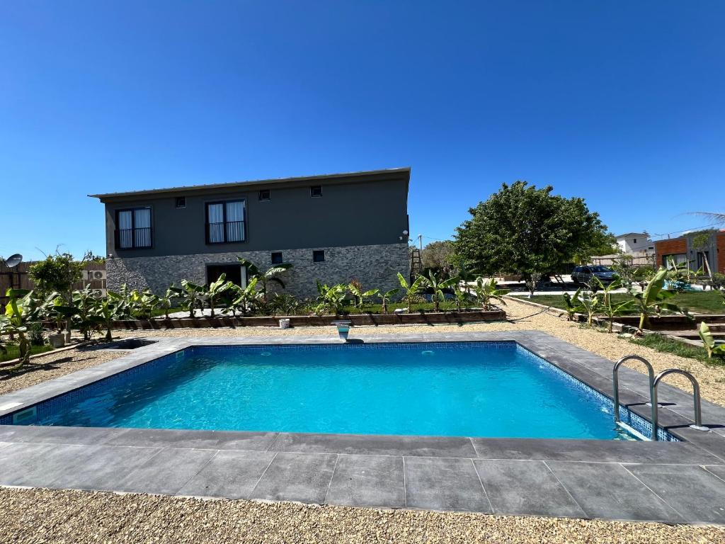 a swimming pool in front of a house at Aden Garden Otel in Cesme