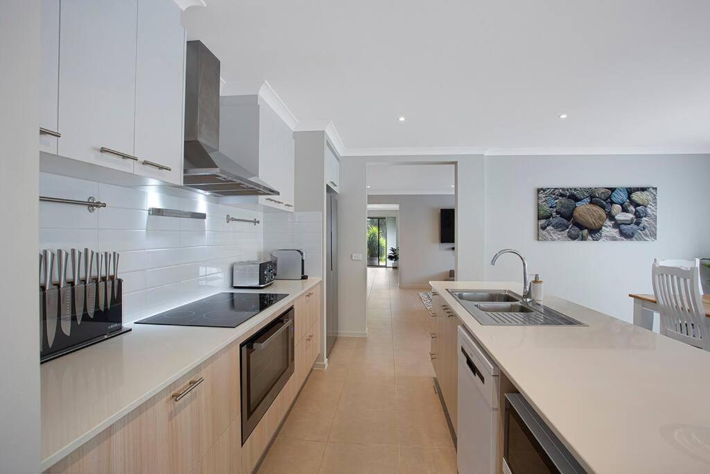 cocina grande con encimeras y electrodomésticos blancos en Cowes Island Retreat, en Cowes