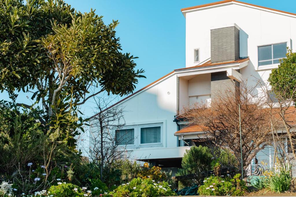 a white house with trees in front of it at 白浜レジデンス 1日1組限定 ファミリー向け 炭火焼イタリアンディナー付き in Minamiboso
