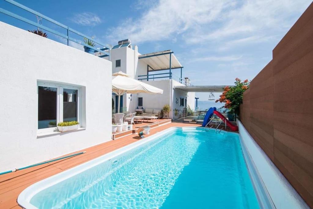 a swimming pool in the backyard of a house at White-Blue Luxury Villa 2 in Pefkali