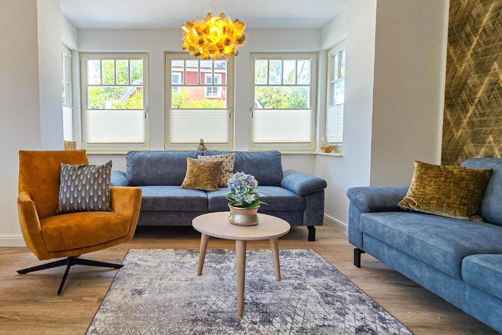 a living room with blue couches and a table at Darss - Duett 2 in Prerow