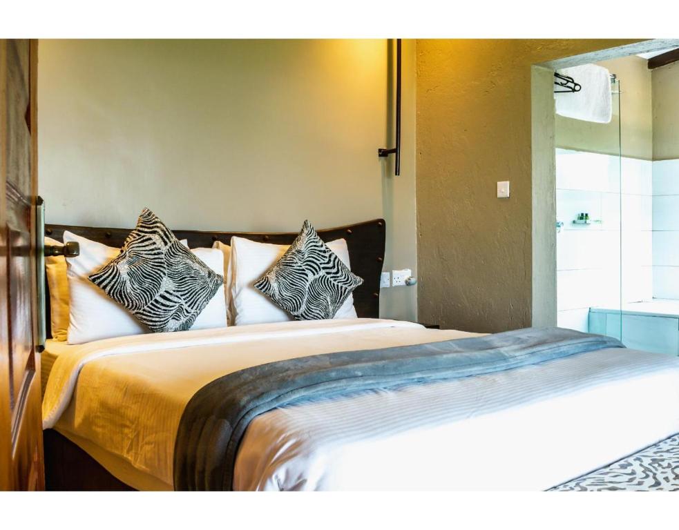 a bedroom with a bed with four pillows on it at Mua Hills Getaway in Katelembu