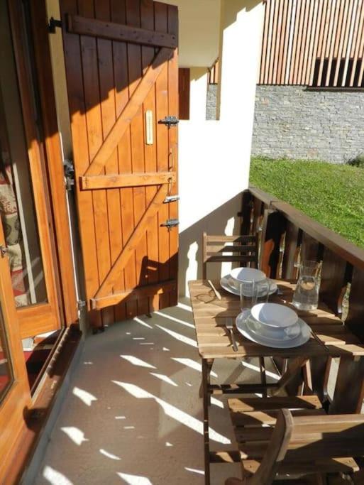 d'une terrasse avec une table et des chaises ainsi qu'une porte en bois. dans l'établissement Gentianes 64B studio proche centre de Châtel - Multipass inclu, à Châtel