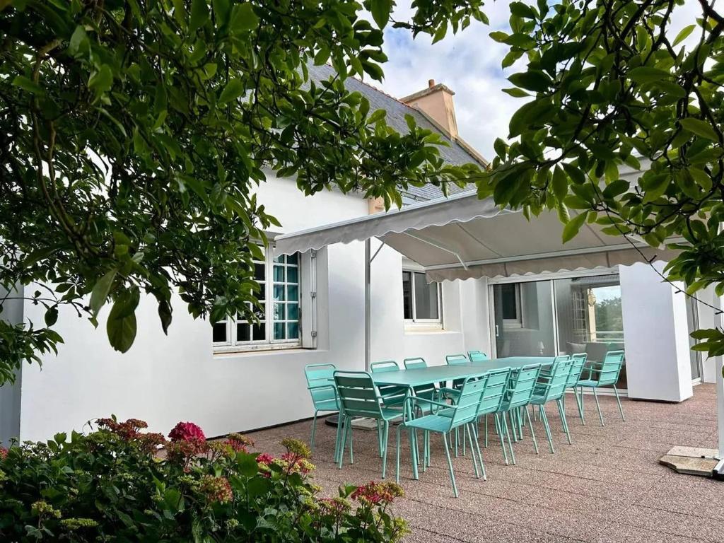 un tavolo e sedie di fronte a una casa bianca di Villa spacieuse Saint-Hernin avec spa convivial a Saint Hernin