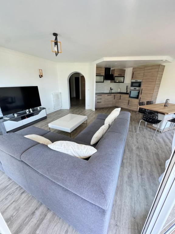 un salon avec un canapé gris et une table dans l'établissement Appartement vue mer, Long Beach, à Cannes