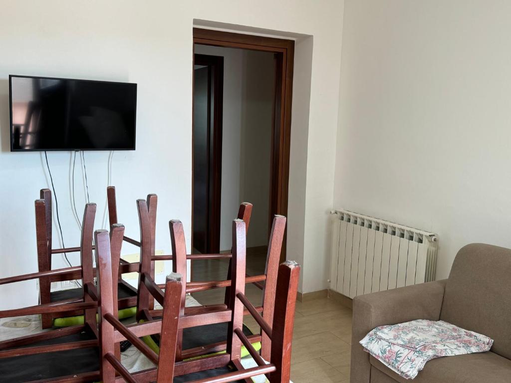 Pokój z 4 drewnianymi krzesłami i stołem w obiekcie Casa Vacanze Cerreto 2 w mieście Miglianico