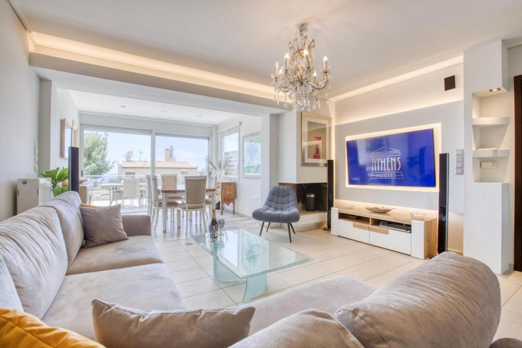 ein Wohnzimmer mit einer Couch und einem Glastisch in der Unterkunft Saronida Hills private Pool in Saronida