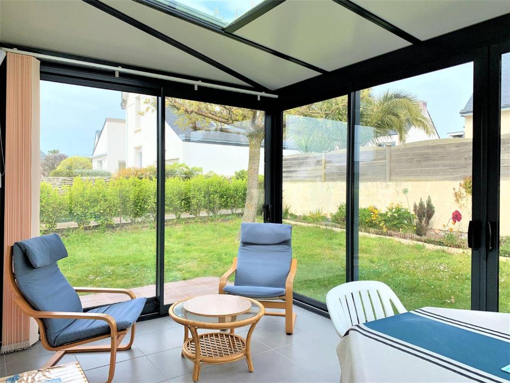 a screened in porch with two chairs and a table at Quiberon : maison 6 pers., 3 ch., jardin, quartier calme - FR-1-478-164 in Quiberon