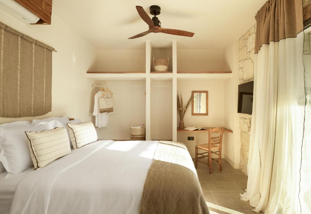 a bedroom with a bed and a ceiling fan at Ergon Beach House Nikiti in Nikiti