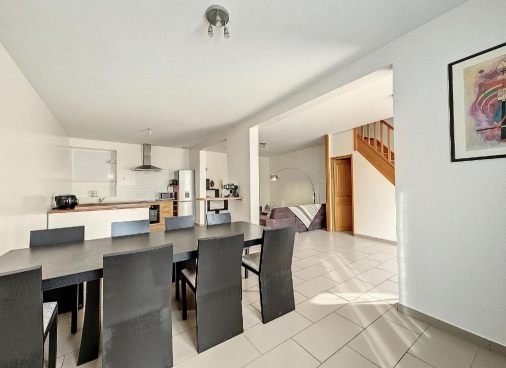 Un comedor y una cocina con mesa y sillas. en Le relais des forges, en Saint-Leu-dʼEsserent