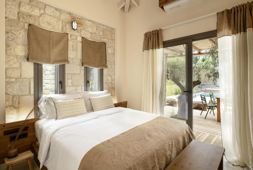 a bedroom with a large bed and a patio at Ergon Beach House Nikiti in Nikiti
