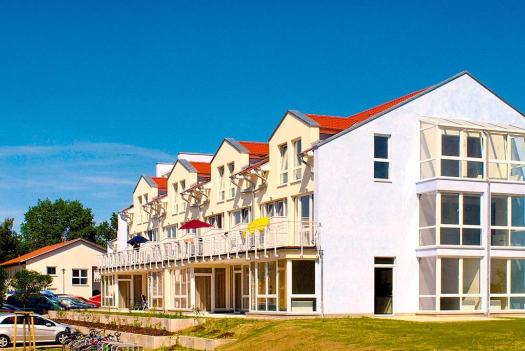 a large white building with a balcony and a car at Residenz Meeresblick D Fewo 111 in Rerik