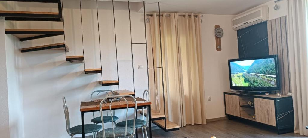 a living room with a television and a table and chairs at Pyramid Holiday House in Visoko