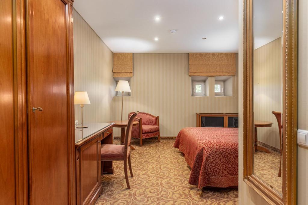 a hotel room with a bed and a desk and a mirror at The Benjamin House in Rīga