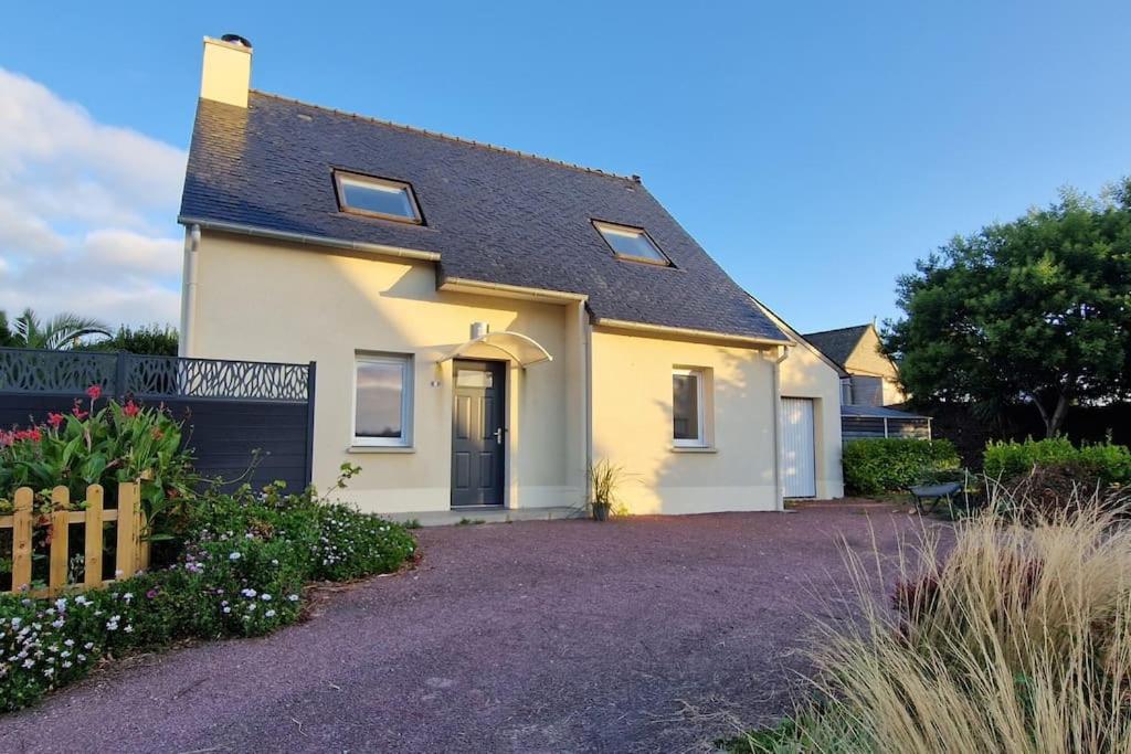 une maison blanche avec une porte noire et une allée. dans l'établissement la Maison des Voyageurs, à Tréflez