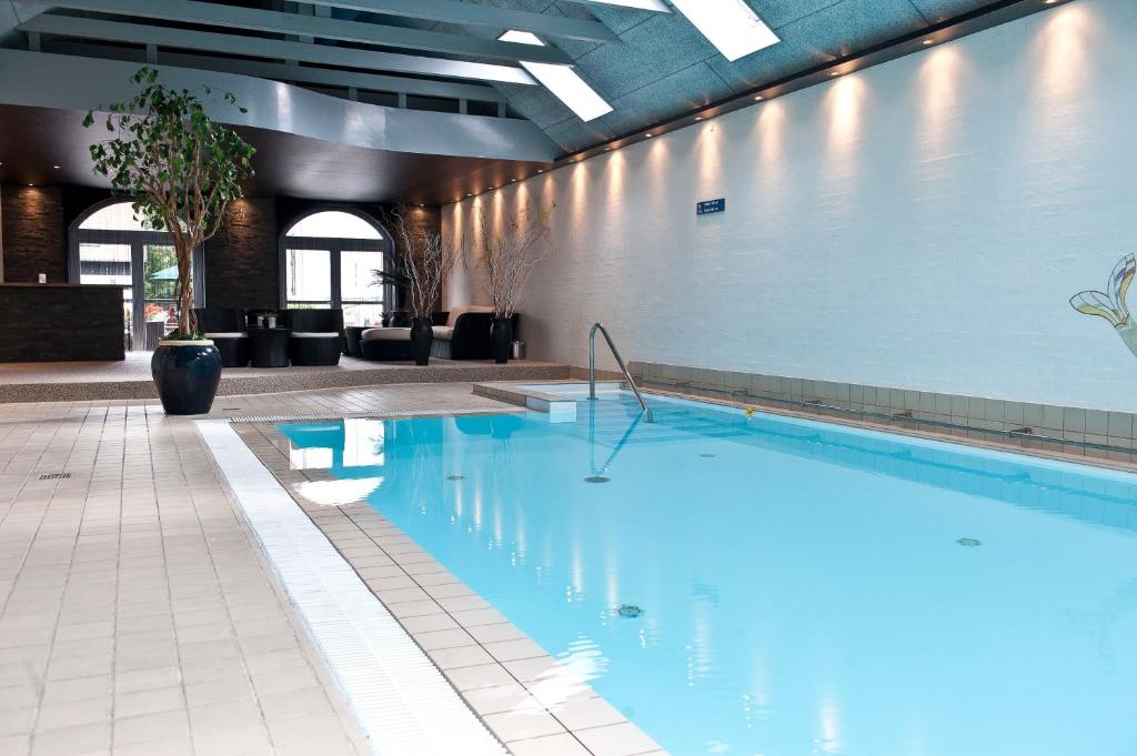 a large swimming pool in a building with a pool at Hotel Scheelsminde in Aalborg