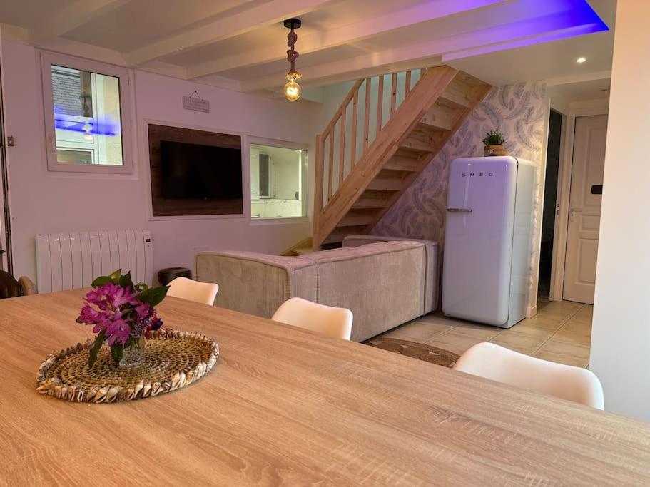 une pièce avec une table avec un réfrigérateur et des escaliers dans l'établissement L Escale, à Perros-Guirec