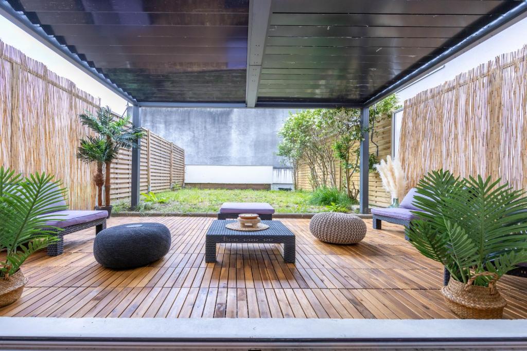 une terrasse en bois avec une table et des chaises. dans l'établissement Le coin du bonheur, à Nantes
