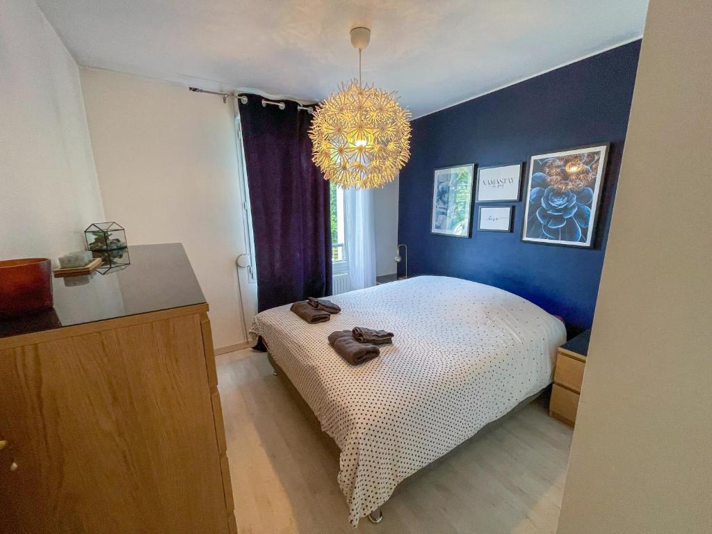 une chambre avec un lit et un lustre dans l'établissement Charmant Appart Neudorf + garage, à Strasbourg