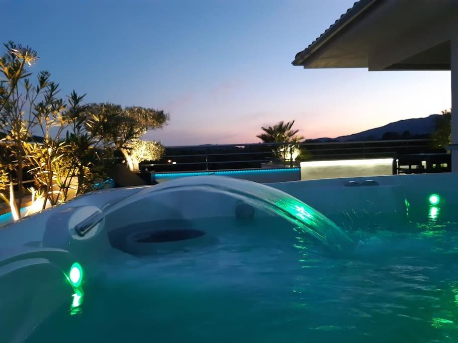 - une piscine avec des lumières vertes dans l'eau dans l'établissement Appartement dernier étage avec spa privatif sur grande terrasse, à Porto-Vecchio