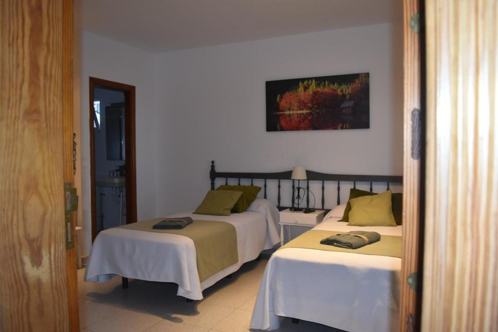 Duas camas estão numa sala com a ritualidade de ritismo de ritismo de ritismo de cristianismo em Apartamentos Sabare em Jerez de la Frontera