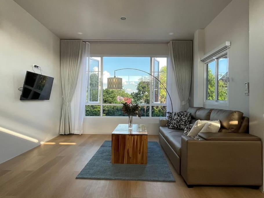 a living room with a couch and a coffee table at Prod Place - Sunny Chiang Rai in Chiang Rai