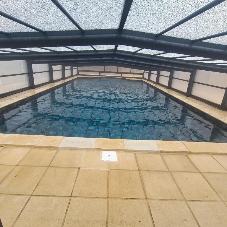 une grande piscine intérieure d'eau bleue dans l'établissement Gte Mimosa - 6 people in the heart of the Dordogne, à Journiac