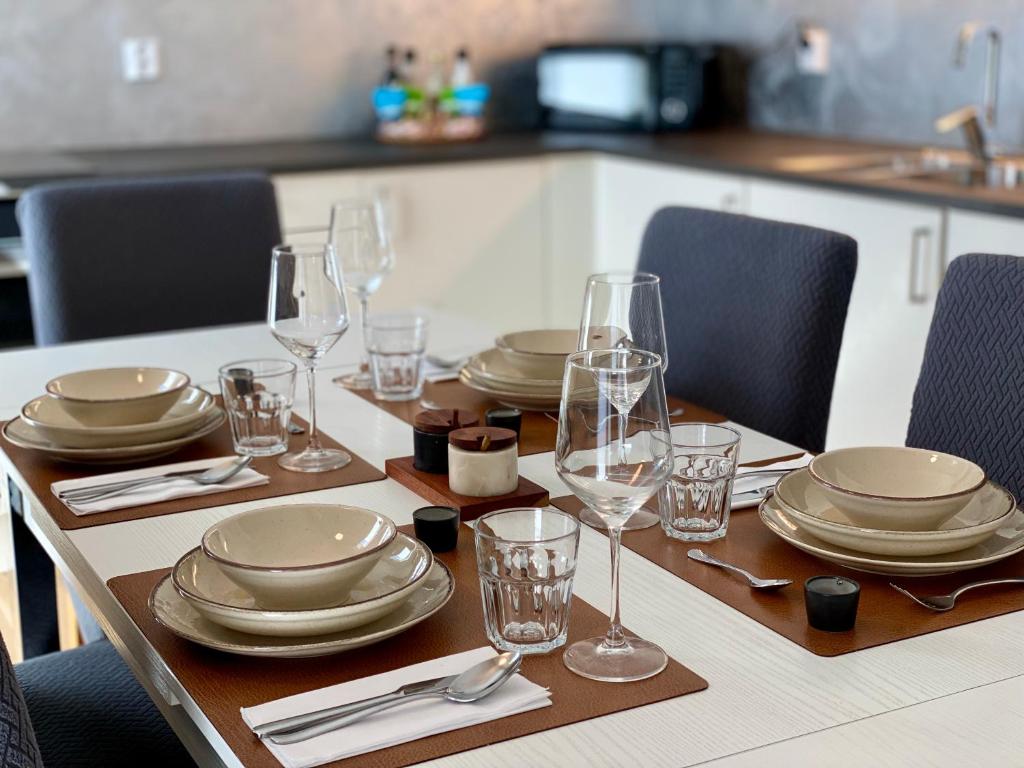 a table with plates and wine glasses on it at Experience a Cozy Getaway Near Pulpit Rock - B unit in Strand