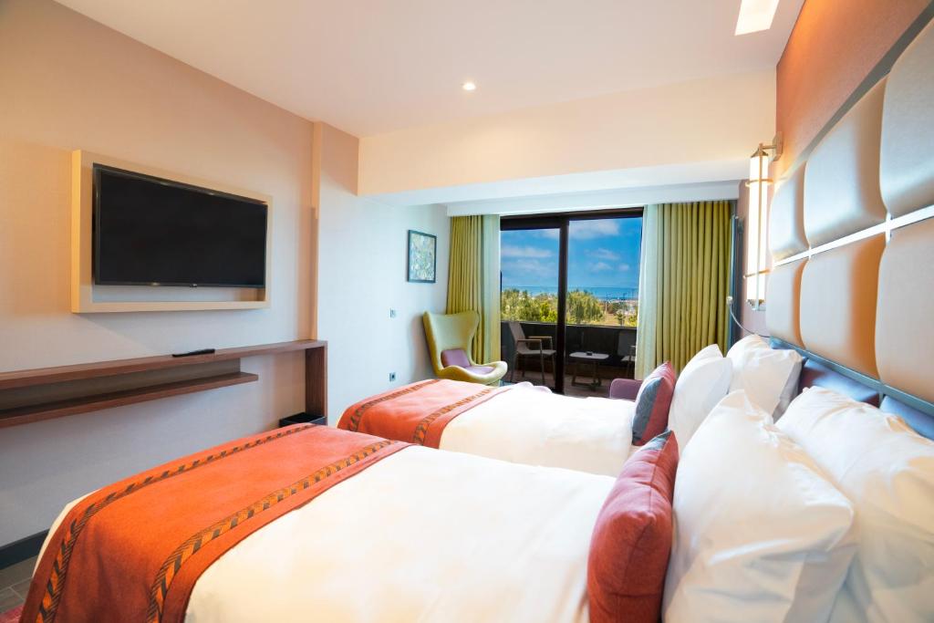 a hotel room with two beds and a flat screen tv at Sile Gonen Hotel in Şile