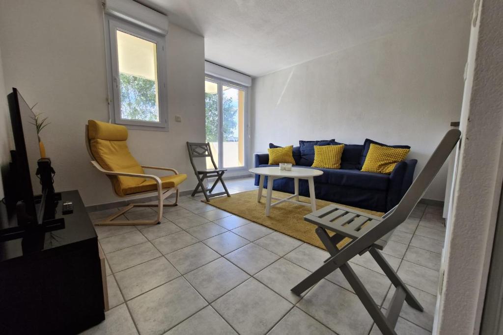 un salon avec un canapé bleu et une table dans l'établissement Beautiful apartment with pool in Touques, à Touques