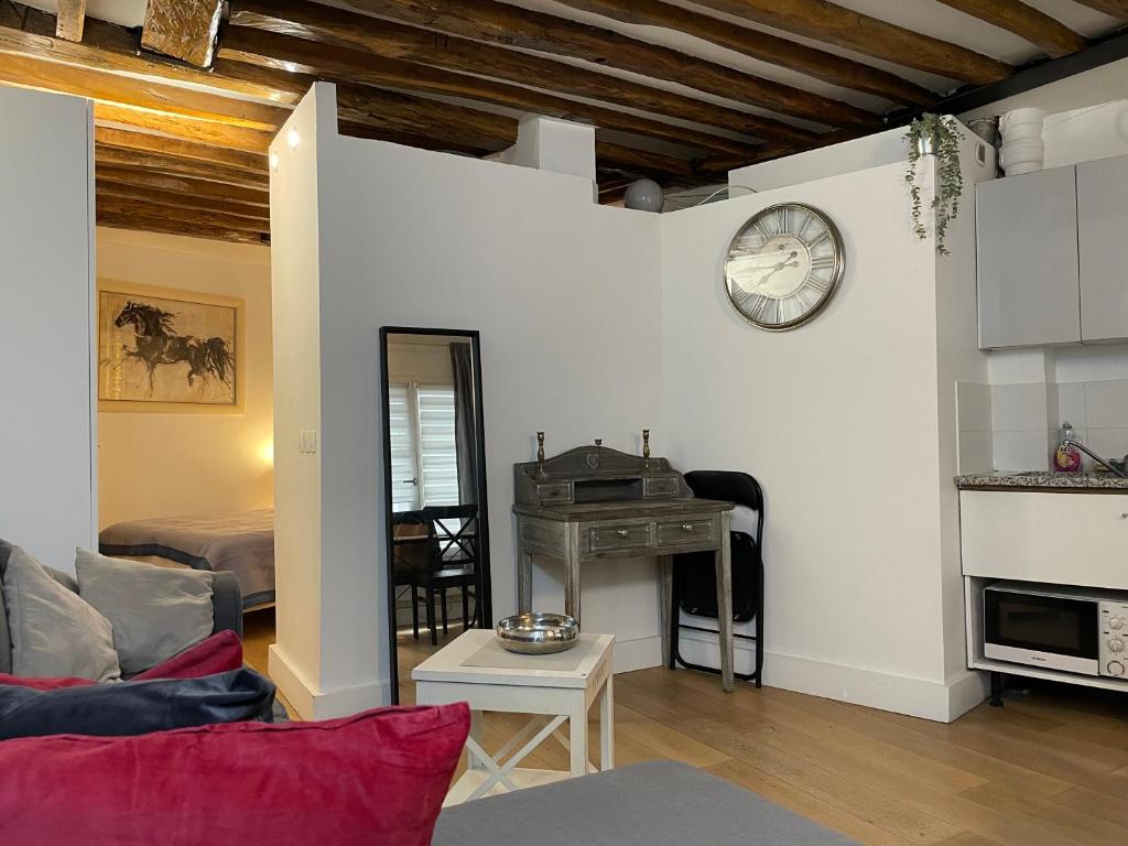 un salon avec un canapé et une horloge au mur dans l'établissement Opera Royal House, à Paris