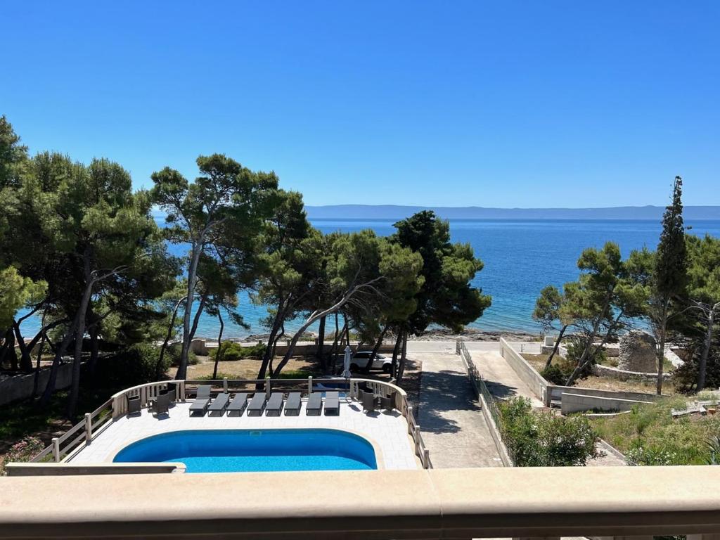 a swimming pool with a view of the ocean at Vila Vera Seafront Apartments in Sumartin
