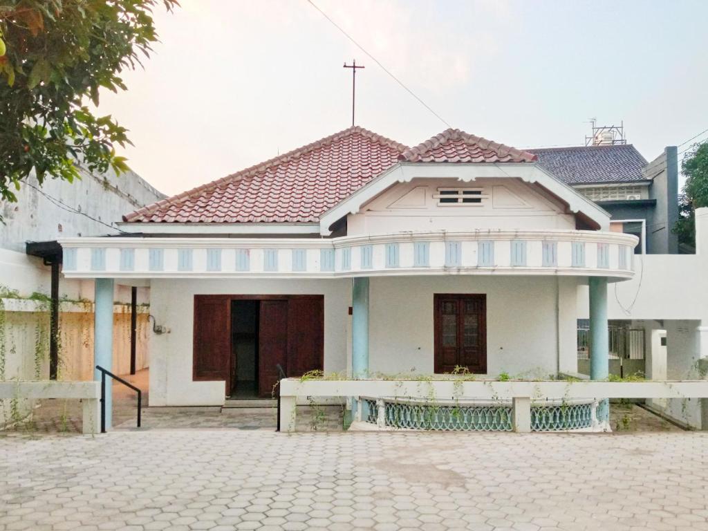 a white house with a cross on the roof at RedDoorz near Alun Alun Kembangjoyo Pati in Pati